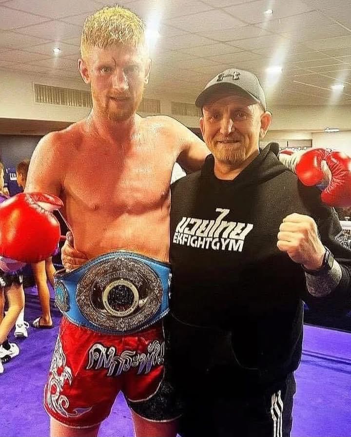 Alex MacGregor with his coach and championship belt after a win